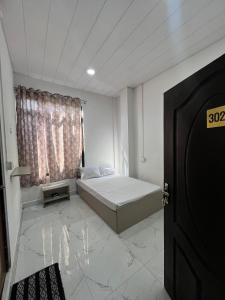 a bedroom with a bed and a window and a door at Aizawl View Hotel in Āīzawl