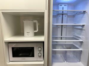 a refrigerator with its door open next to a microwave at 더 디셈버스테이 인 한라 in Taeam