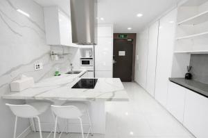 a white kitchen with white counters and white appliances at 더 디셈버스테이 인 한라 in Taeam +12 photos