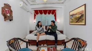 a man and a woman sitting on a bed at Zostel Udaipur in Udaipur