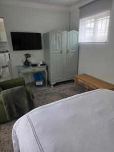 a bedroom with a bed and a tv and a couch at Pennington Splendor Apartment in Pennington