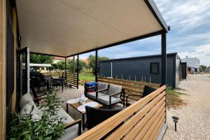 an outdoor patio with tables and chairs and a building at Sea Mobile Home in Sukošan