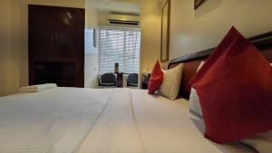 a hotel room with a large bed with red pillows at Hotel Fort in Patna
