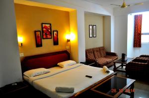 a bedroom with a bed and a living room at Hotel Fort in Patna