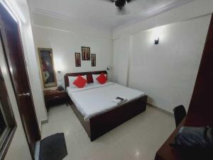a bedroom with a bed with red pillows on it at Hotel Fort in Patna
