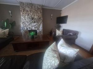 a living room with a couch and a fireplace at The Ranch House at African Safari Lodge in Grahamstown