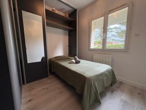 a small bedroom with a bed and a window at Maison proche du zénith à Clermont Ferrand Sud in La Roche-Blanche