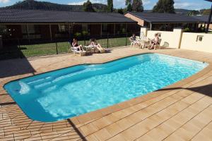 
a swimming pool with a pool table and chairs at Zig Zag Motel & Apartments in Lithgow
