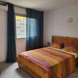 a bedroom with a large bed and a window at Résidence NOHA in Abidjan