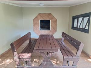 a wooden bench sitting in a room with a fireplace at Shore Breakers in Shelly Beach