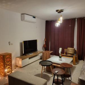 a living room with a television and a table and chairs at Résidence NOHA in Abidjan