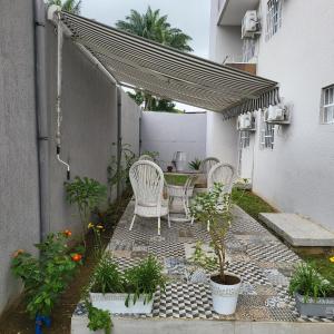 a patio with a table and chairs and plants at Résidence NOHA in Abidjan