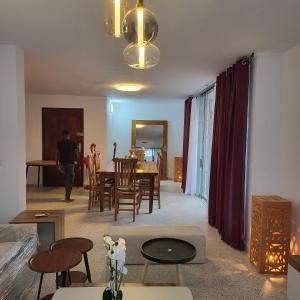 a man walking through a living room with a table and chairs at Résidence NOHA in Abidjan