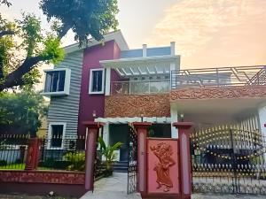 a pink house with a gate in front of it at Swapno Chhobi in Bolpur +14 photos