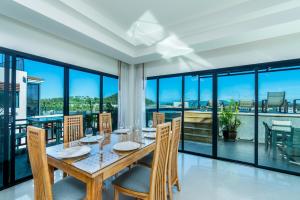a dining room with a table and views of the city at Surin Sabai Residence near Surin Beach in Surin Beach
