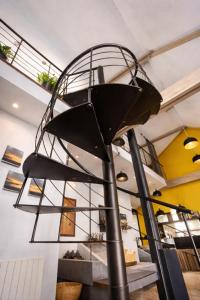a metal spiral staircase in a building with a stair case at le Sunset Loft 88 maison neuve et moderne in Sainte-Adresse