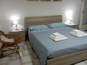 a bedroom with a bed with two towels on it at Villetta Generosa in Torre Lapillo