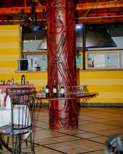 a red column in a restaurant with a table with wine glasses at Arusha Centre Rooms in Arusha
