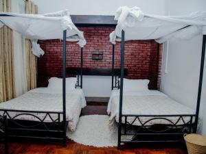 two bunk beds in a room with a brick wall at Arusha Centre Rooms in Arusha