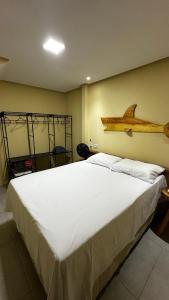 a bedroom with a large bed with a log on the wall at Chalés Boqueirão beach in Japaratinga +43 photos