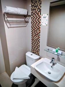 a bathroom with a white toilet and a sink at Sahid Mutiara Karawaci in Tangerang +12 photos