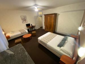 a hotel room with two beds and a desk at Nouvel Hotel in Lons-le-Saunier