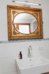an old mirror above a sink in a bathroom at Stilvoll und ruhig in Füssen +25 photos
