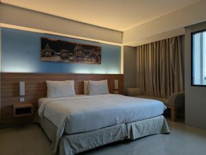 a hotel room with a large bed and a chair at Sahid Mutiara Karawaci in Tangerang