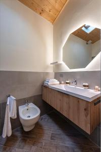 a bathroom with a sink and a toilet and a mirror at L' Abbraccio in Caiolo +16 photos