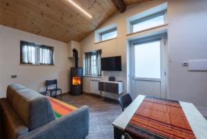 a living room with a couch and a table and a fireplace at L' Abbraccio in Caiolo