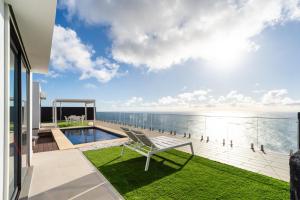a view of the ocean from the balcony of a house at GuestReady - The Ocean El Cid in Fajã da Ovelha