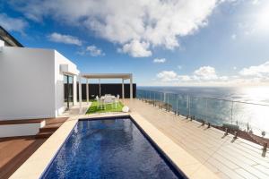 a swimming pool on the deck of a house at GuestReady - The Ocean El Cid in Fajã da Ovelha
