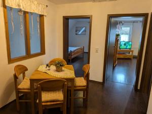 a dining room with a table and chairs and a bedroom at Ferienwohnung Eiernest in Briedeler Heck +16 photos
