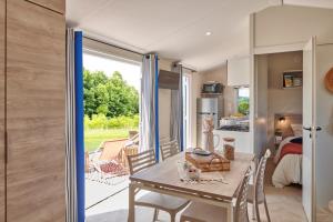 a kitchen and dining room with a table and chairs at Camping les Chalands Fleuris in Saint-André-des-Eaux