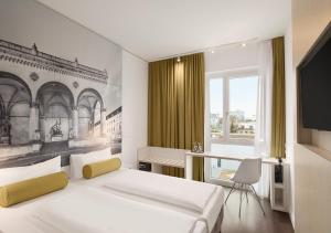 a bedroom with two beds and a desk and a television at Super 8 by Wyndham Munich City North in Munich
