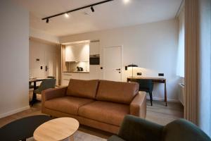a living room with a couch and a table at Georges Henri Aparthotel in Brussels