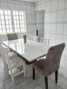 a white dining room table with chairs and a mirror at Casa Laguna in Laguna