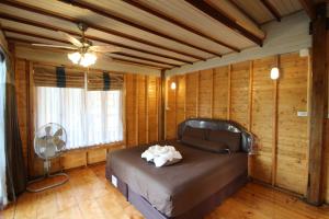 a bedroom with a bed in a room with wooden walls at Longbay Lipe in Ko Lipe