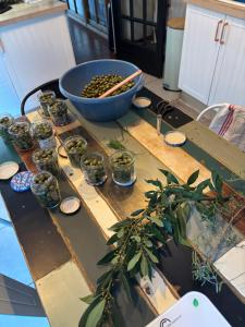 a table with a bowl and jars of olives on it at La Pause Bonheur La Campagnarde in Luc-sur-Orbieu