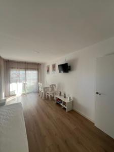 a white room with a bed and a table with chairs at Diplomatic Salou in Salou