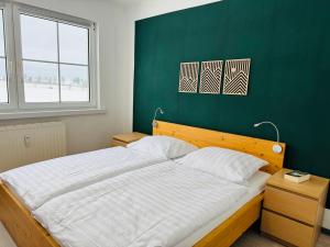 a bedroom with a large bed with a green wall at FeWo Einetal 4 im schönen Ostharz in Schielo
