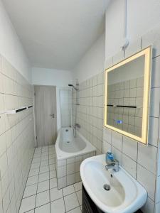 a white bathroom with a sink and a bath tub at FeWo Einetal 4 im schönen Ostharz in Schielo