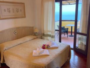a bedroom with a bed with towels and a balcony at Torre delle Stelle Residence Aura Club in Torre delle Stelle +70 photos