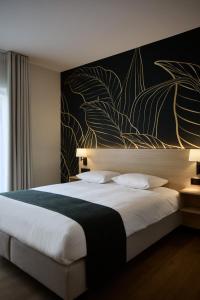a bedroom with a large bed with a painting on the wall at Georges Henri Aparthotel in Brussels