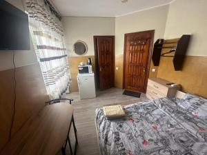 a small room with a bed and a kitchen at Бордуляка 11 in Ternopil