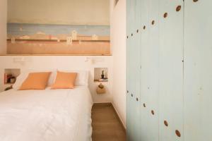 a bedroom with a white bed and a painting on the wall at The Wave House in Jávea