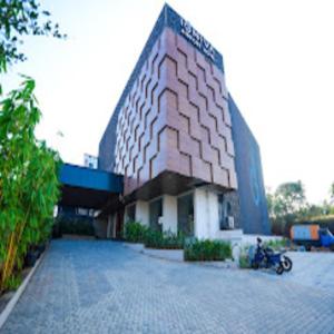 a building with a motorcycle parked in front of it at IGNIVA Airport Hotel in Calicut