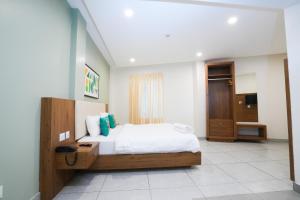 a bedroom with a bed and a television in it at IGNIVA Airport Hotel in Calicut