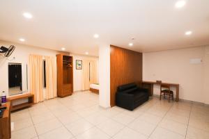 a living room with a black couch and a table at IGNIVA Airport Hotel in Calicut