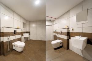 a bathroom with two toilets and a sink at IGNIVA Airport Hotel in Calicut +12 photos